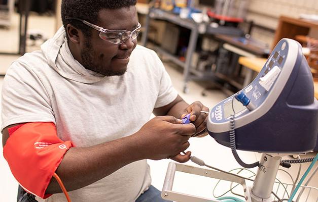 A Student Working on a Machine. 